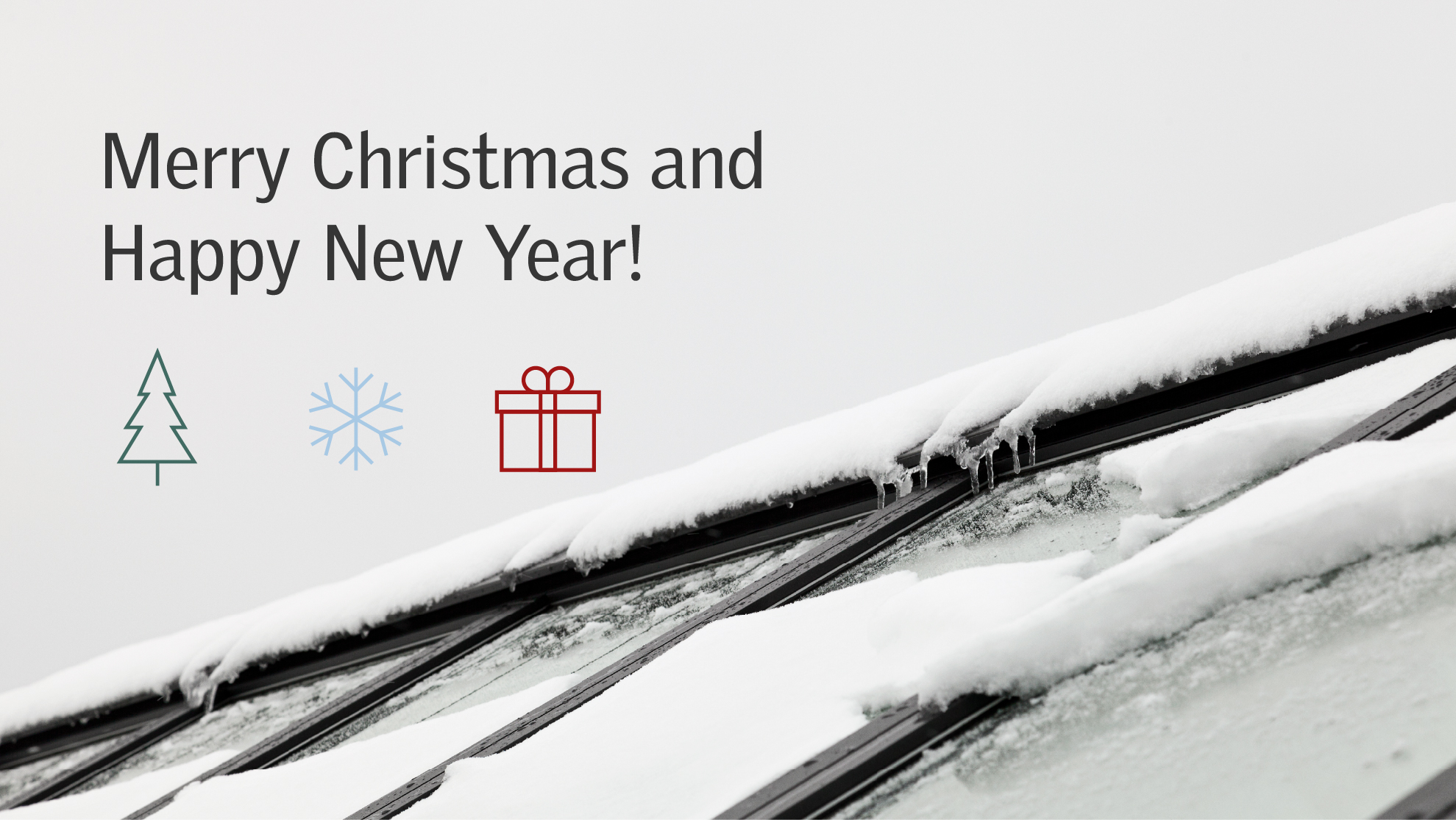 Snow-covered VELUX Commercial roof window with holiday message and icons